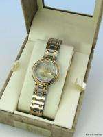 Features a round, polished Silver Tone case with a gold tone bezel