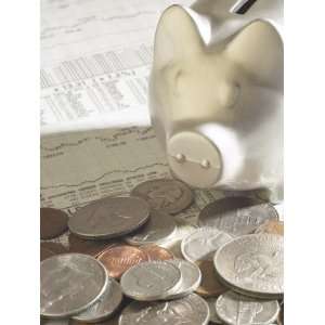 Silver Piggy Bank on Top of Pile of American Coins and Stock Market 